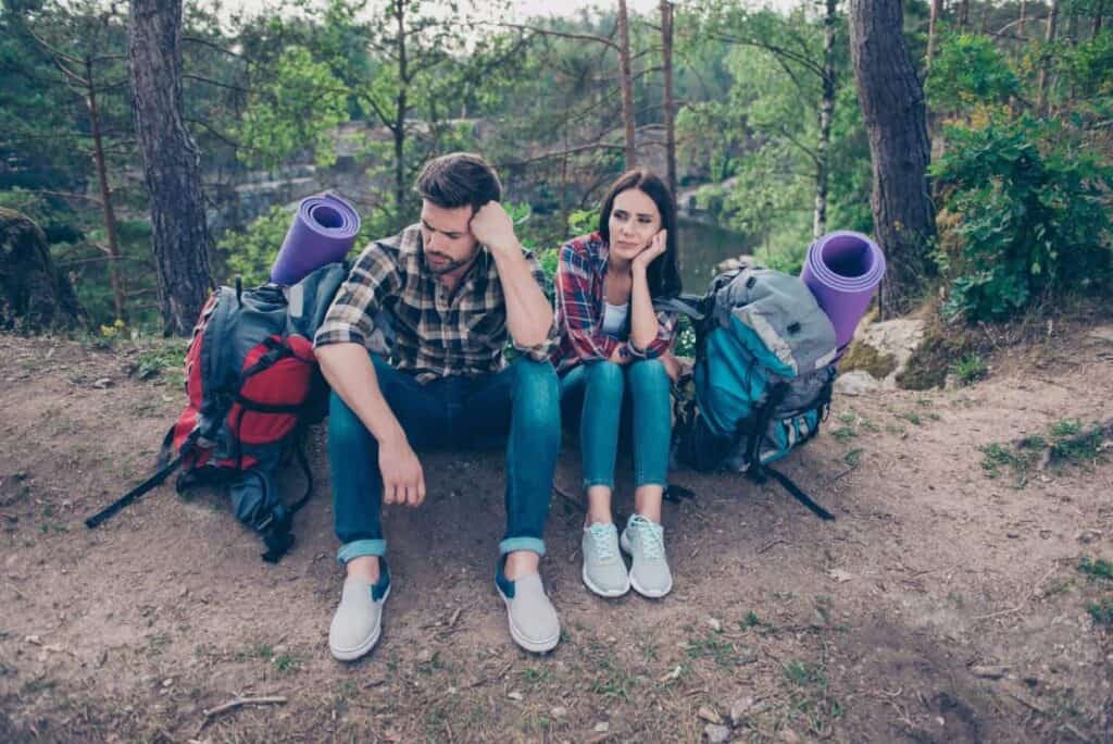 couple-sitting-on-side-of-trail-grumpy