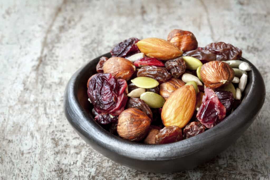 black-bowl-of-trail-mix-almonds-pumpkin-seeds-raisins-sunflower-seeds