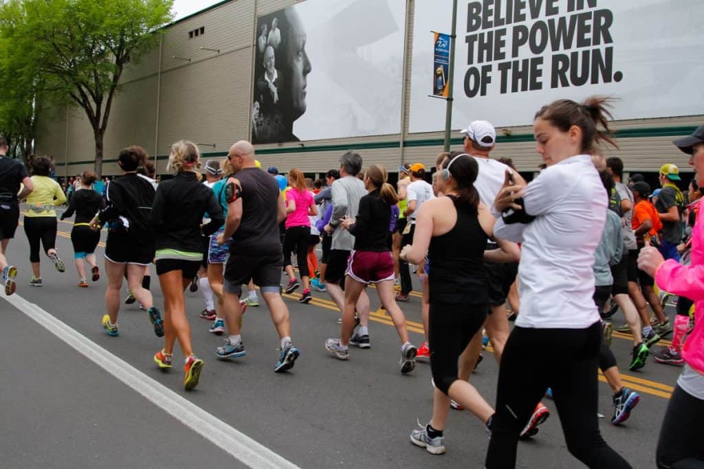 people-running-marathon-woman-slow-jog-in-foreground