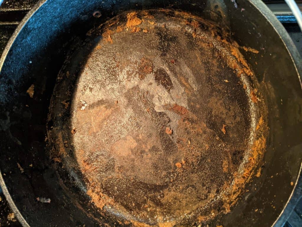 dirty-cast-iron-dutch-oven-inside-cooked-on-food