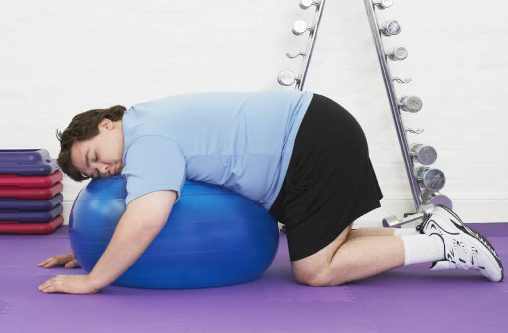 overweight man resting on exercise ball